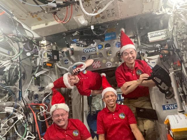 NASA image: Four Expedition 74 astronauts pose for a festive portrait celebrating the holiday season