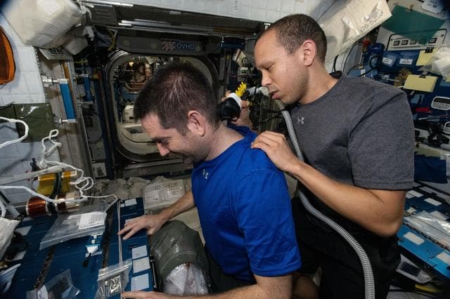 NASA image: NASA astronaut Chris Williams trims the hair of fellow NASA astronaut Jack Hathaway