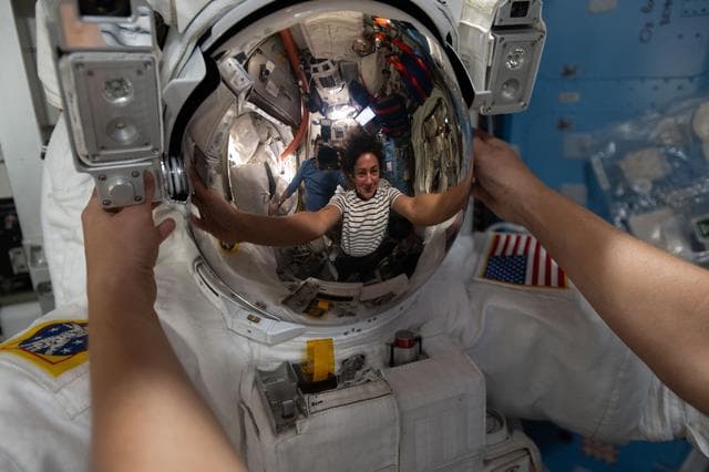 NASA image: NASA astronaut Jessica Meir’s reflection is captured in a spacesuit helmet visor