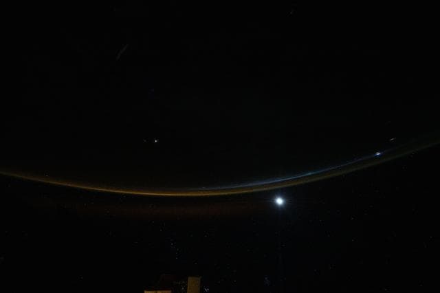 NASA image: A dim airglow blankets Earth’s horizon as a faint Moon sets above the Indian Ocean