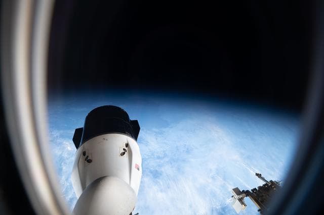 NASA image: Peering out a window of a SpaceX Dragon spacecraft toward another Dragon spacecraft