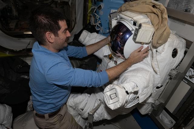 NASA image: NASA astronaut Jack Hathaway works on a spacesuit inside the Quest airlock