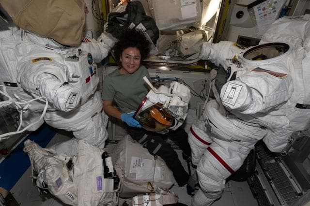 NASA image: NASA astronaut Jessica Meir smiles for a portrait while preparing a helmet for installation
