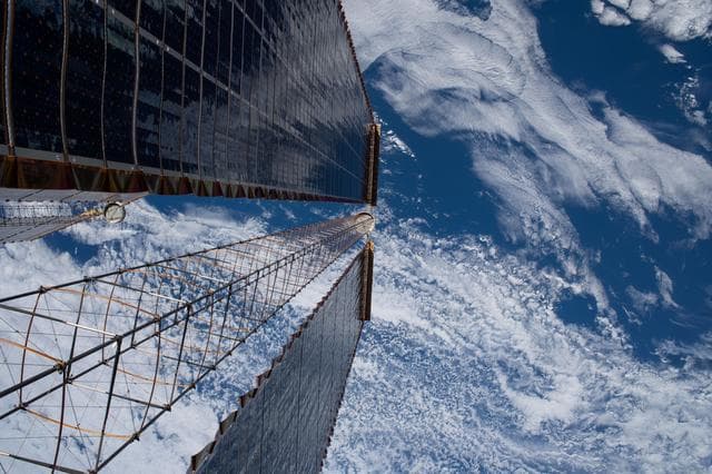 NASA image: A view peering down a pair of the International Space Station's roll-out solar arrays
