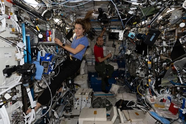 NASA image: Astronauts Sophie Adenot and Chris Williams work together inside the Columbus laboratory module