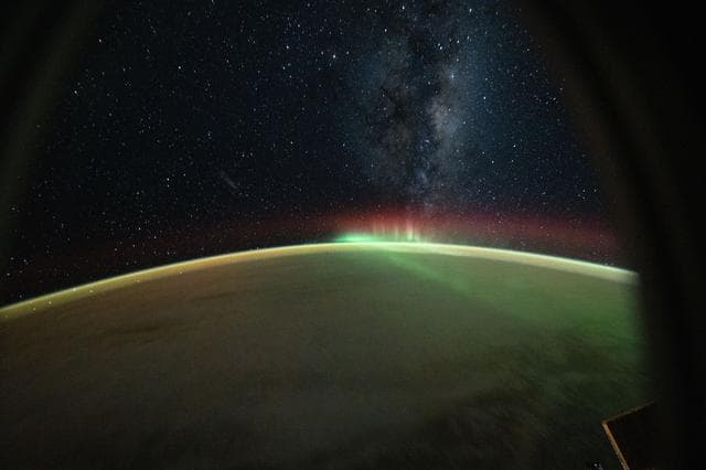 NASA image: A wispy aurora australis arcs across the Indian Ocean benaeth the Milky Way