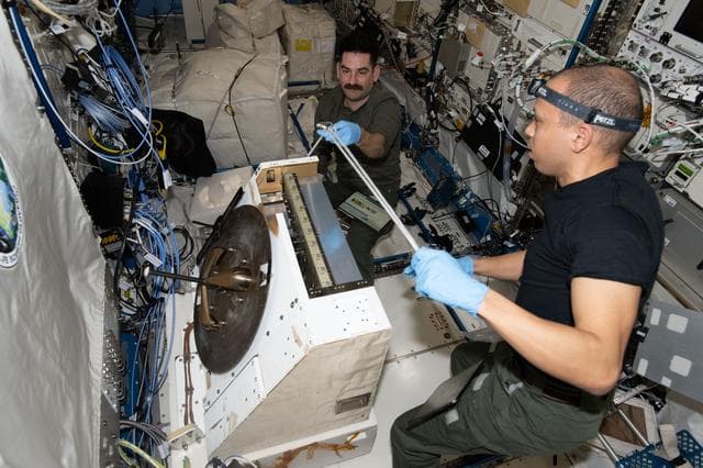 NASA image: Astronauts Jack Hathaway and Chris Williams prepare the NanoRacks External Platform carrying three scientific payloads