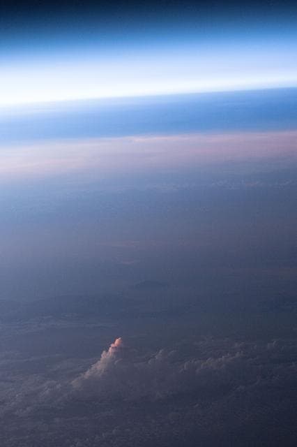 NASA image: An orbital sunset softens Earth’s atmosphere and cloud tops with light pink and blue hues
