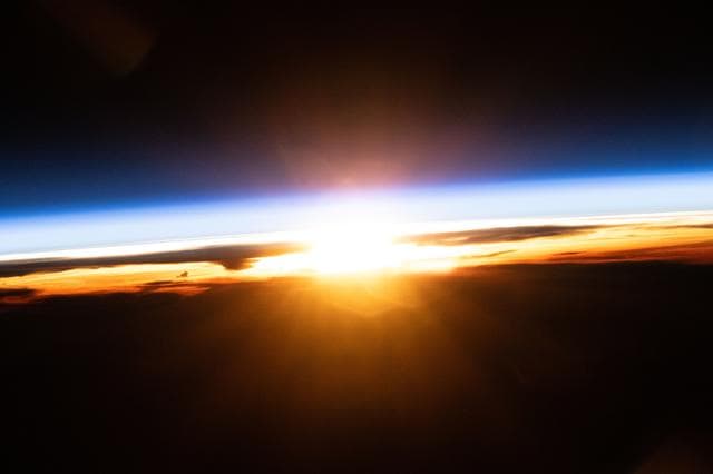 NASA image: The last rays of an orbital sunset illuminate Earth's atmosphere and the cloud tops