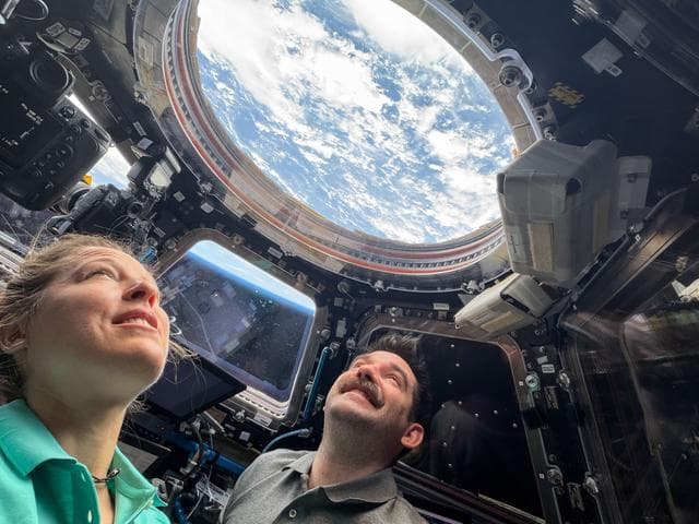 NASA image: Astronauts Sophie Adenot and Jack Hathaway look out a window in the cupola