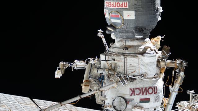 NASA image: Cosmonaut Sergei Mikaev works outside the International Space Station's Poisk module in his Orlan spacesuit with blue stripes
