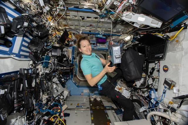 NASA image: ESA astronaut Sophie Adenot shows off an Advanced Space Experiment Sample Processor-4 research cassette