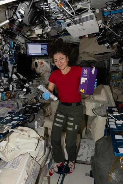NASA image: NASA astronaut Jessica Meir activates tubes filled with microbial and botanical samples