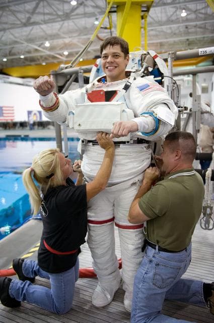 NASA image: STS-130 crew members George Zamka, Steve Robinson helping Robert Behnken and Nick Patrick 