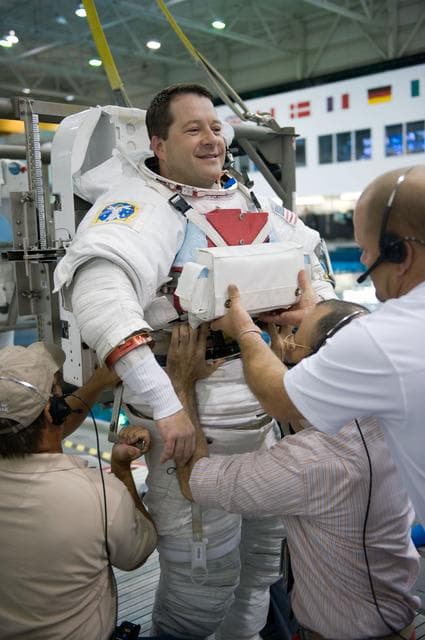 NASA image: STS-130 crew members George Zamka, Steve Robinson helping Robert Behnken and Nick Patrick 