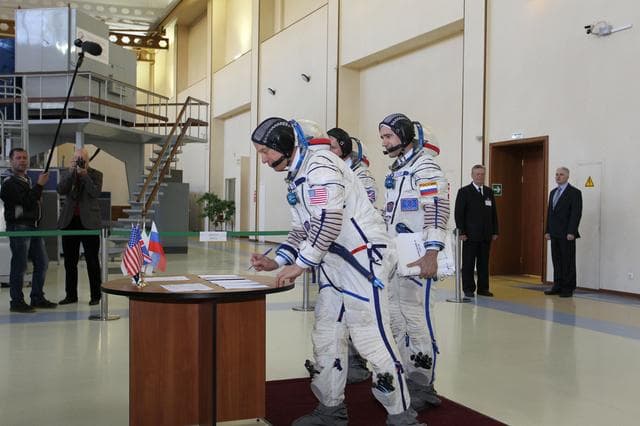 NASA image: CG4G8721 --- (6 May 2015) --- At the Gagarin Cosmonaut Training Center in Star City, Russia, Expedition 44/45 backup Flight Engineer Timothy Kopra of NASA signs in for the first of two days of qualification exams May 6 as his crewmates, Yuri Malenchenko of the Russian Federal Space Agency (Roscosmos, center) and Timothy Peake of the European Space Agency (left) look on. They are the backups to the prime crew --- Kjell Lindgren of NASA, Oleg Kononenko of Roscosmos and Kimya Yui of the Japan Aerospace Exploration Agency --- who are in the final stages of training for launch May 27, Kazakh time, in the Soyuz TMA-17M spacecraft to begin a five and a half month mission to the International Space Station. Photo credit: NASA/Seth Marcantel