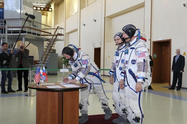 NASA image: CG4G8732 --- (6 May 2015) --- At the Gagarin Cosmonaut Training Center in Star City, Russia, Expedition 44/45 backup Flight Engineer Timothy Peake of the European Space Agency signs in for the first of two days of qualification exams May 6 as his crewmates, Yuri Malenchenko of the Russian Federal Space Agency (Roscosmos, center) and Timothy Kopra of NASA (right) look on. They are the backups to the prime crew --- Kjell Lindgren of NASA, Oleg Kononenko of Roscosmos and Kimya Yui of the Japan Aerospace Exploration Agency --- who are in the final stages of training for launch May 27, Kazakh time, in the Soyuz TMA-17M spacecraft to begin a five and a half month mission to the International Space Station. Photo credit: NASA/Seth Marcantel