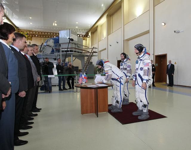 NASA image: CG4G8740_1 --- (6 May 2015) --- At the Gagarin Cosmonaut Training Center in Star City, Russia, Expedition 44/45 backup Soyuz Commander Yuri Malenchenko of the Russian Federal Space Agency (Roscosmos) signs in for the first of two days of qualification exams May 6 as his crewmates, Timothy Peake of the European Space Agency (left) and Timothy Kopra of NASA (right) look on. They are the backups to the prime crew --- Kjell Lindgren of NASA, Oleg Kononenko of Roscosmos and Kimya Yui of the Japan Aerospace Exploration Agency --- who are in the final stages of training for launch May 27, Kazakh time, in the Soyuz TMA-17M spacecraft to begin a five and a half month mission to the International Space Station. Photo credit: NASA/Seth Marcantel