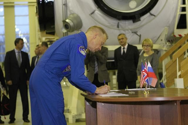 NASA image: At the Gagarin Cosmonaut Training Center in Star City, Russia, Expedition 46-47 prime crewmember Tim Kopra of NASA signs in for the start of two days of qualification exams Nov. 19. Kopra, Yuri Malenchenko of the Russian Federal Space Agency (Roscosmos) and Tim Peake of the European Space Agency will launch Dec. 15 in the Soyuz TMA-19M spacecraft from the Baikonur Cosmodrome in Kazakhstan for a six-month mission on the International Space Station..NASA/Seth Marcantel
