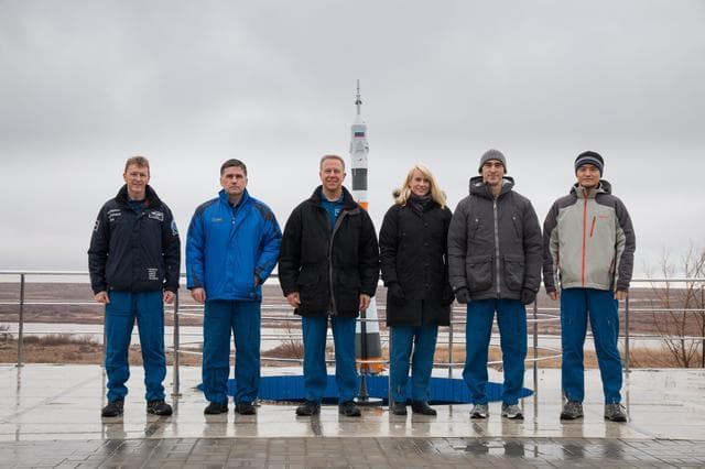 NASA image: Behind their Cosmonaut Hotel crew quarters in Baikonur, Kazakhstan, the prime and backup Expedition 46-47 crewmembers pose for pictures Dec. 9 during a break in their training. From left to right are prime crewmembers Tim Peake of the European Space Agency, Yuri Malenchenko of the Russian Federal Space Agency and Tim Kopra of NASA, and backup crewmembers Kate Rubins of NASA, Anatoly Ivanishin of Roscosmos and Takuya Onishi of the Japan Aerospace Exploration Agency. Kopra, Peake and Malenchenko will launch Dec. 15 on their Soyuz TMA-19M spacecraft for a six-month mission on the International Space Station...NASA/Victor Zelentsov.