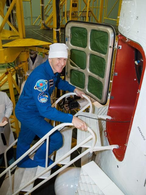 NASA image: In the Integration Facility at the Baikonur Cosmodrome in Kazakhstan, Expedition 46-47 crewmember Tim Peake of the European Space Agency flashes a smile before entering his Soyuz spacecraft Dec. 10 during a final fit check and inspection. Peake, Tim Kopra of NASA and Yuri Malenchenko of the Russian Federal Space Agency (Roscosmos) will launch Dec. 15 on the Soyuz TMA-19M spacecraft for a six-month mission on the International Space Station...NASA/Victor Zelentsov.