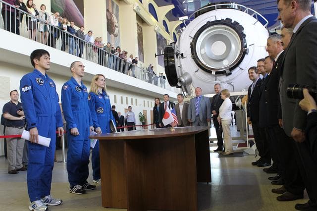 NASA image: At the Gagarin Cosmonaut Training Center in Star City, Russia, Expedition 48-49 prime crewmembers Takuya Onishi of the Japan Aerospace Exploration Agency (left), Anatoly Ivanishin of Roscosmos (center) and Kate Rubins of NASA (right) report to officials May 26 at the start of final qualification exams. Rubins, Onishi and Ivanishin will launch June 24 on the Soyuz MS-01 spacecraft from the Baikonur Cosmodrome in Kazakhstan for a four-month mission on the International Space Station...NASA/Stephanie Stoll.