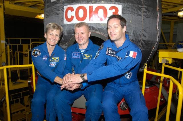 NASA image: In the Integration Facility at the Baikonur Cosmodrome in Kazakhstan, Expedition 48-49 backup crewmembers Peggy Whitson of NASA (left), Oleg Novitskiy of Roscosmos (center) and Thomas Pesquet of the European Space Agency (right) pose for pictures June 25 in front of the Soyuz MS-01 spacecraft during a �ޔfit check��� dress rehearsal activity. Prime crewmembers Kate Rubins of NASA, Anatoly Ivanishin of Roscosmos and Takuya Onishi of the Japan Aerospace Exploration Agency will launch on July 7, Baikonur time, on the Soyuz MS-01 for a planned four-month mission on the International Space Station...NASA/Alexander Vysotsky.