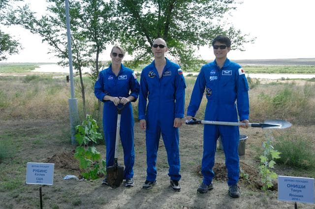 NASA image: At the Cosmonaut Hotel in Baikonur, Kazakhstan, Expedition 48-49 crewmembers Kate Rubins of NASA (left), Anatoly Ivanishin of Roscosmos (center) and Takuya Onishi of the Japan Aerospace Exploration Agency (right) pose for pictures June 30 after Rubins and Onishi, both first-time fliers, planted trees in their names in traditional pre-launch activities. Rubins, Ivanishin and Onishi will launch July 7, Baikonur time, on the Soyuz MS-01 spacecraft for a planned four-month mission on the International Space Station...NASA/Alexander Vysotsky.