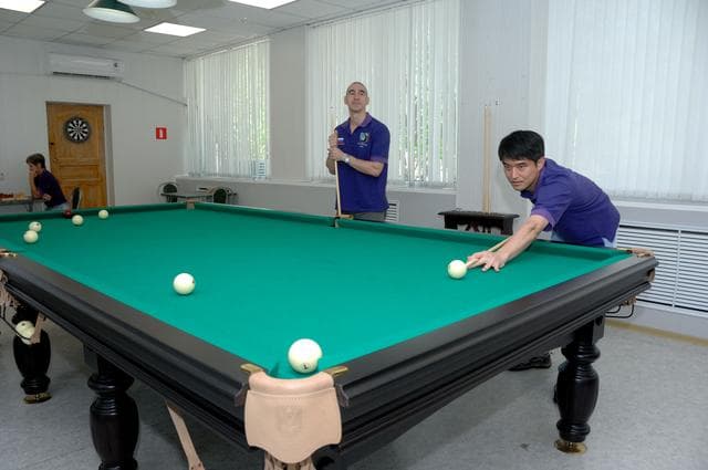 At the Cosmonaut Hotel in Baikonur, Kazakhstan, Expedition 48-49 crewmember Takuya Onishi of the Japan Aerospace Exploration Agency (right) tries his hand at billiards June 30 during pre-launch activities as his crewmate, Anatoly Ivanishin of Roscosmos looks on. In the background on the left, backup crewmember Peggy Whitson of NASA participates in a game of chess. Onishi, Ivanishin and Kate Rubins of NASA will launch July 7, Baikonur time, on the Soyuz MS-01 spacecraft for a planned four-month mission on the International Space Station...NASA/Alexander Vysotsky.