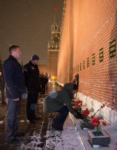 NASA image: jsc2017e136055 - On a snowy night at Red Square in Moscow, Expedition 54-55 backup crewmember Jeanette Epps of NASA lays flowers at the Kremlin Wall where Russian space icons are interred in traditional pre-launch ceremonies Nov. 30. Looking on are backup