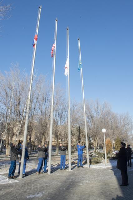 NASA image: jsc2017e136940 - At the Cosmonaut Hotel crew quarters in Baikonur, Kazakhstan, the Expedition 54-55 prime and backup crewmembers raise the flags of Russia, the United States, Japan and Kazakhstan Dec. 6 in traditional pre-launch ceremonies. Anton Shkaplero