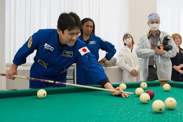NASA image: jsc2017e137338 - At the Cosmonaut Hotel crew quarters in Baikonur, Kazakhstan, Expedition 54-55 prime crewmember Norishige Kanai of the Japan Aerospace Exploration Agency (JAXA) tries his hand at a game of billiards Dec. 11 during a break in pre-launch tr