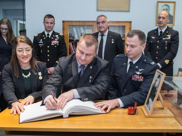 NASA image: jsc2019e004424 - At the Gagarin Museum in the Gagarin Cosmonaut Training Center in Star City, Russia, Expedition 59 crewmembers Christina Koch of NASA (front, left), Alexey Ovchinin of Roscosmos (front, center) and Nick Hague of NASA (front, right) sign a