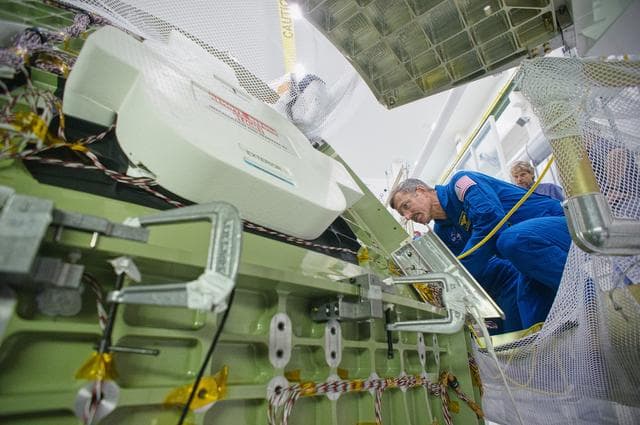 NASA image: Astronaut Dan Burbank examines work on EFT-1 Crew Module
