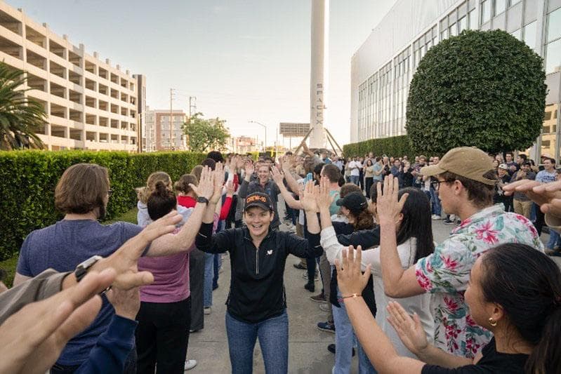 NASA astronaut Anne McClain smiles and high fives SpaceX employees
