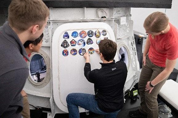 NASA astronaut Anne McClain places Crew-10 mission sticker