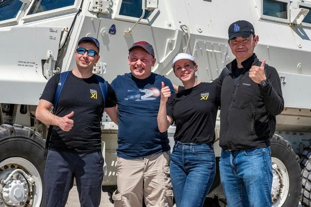 NASA image: NASA's SpaceX Crew-11 members pose for a portrait by an emergency egress vehicle