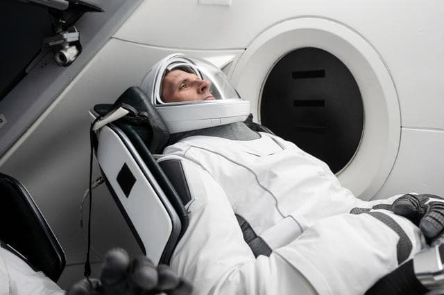 NASA image: CSA astronaut Josh Kutryk is seated inside a mockup Dragon spacecraft