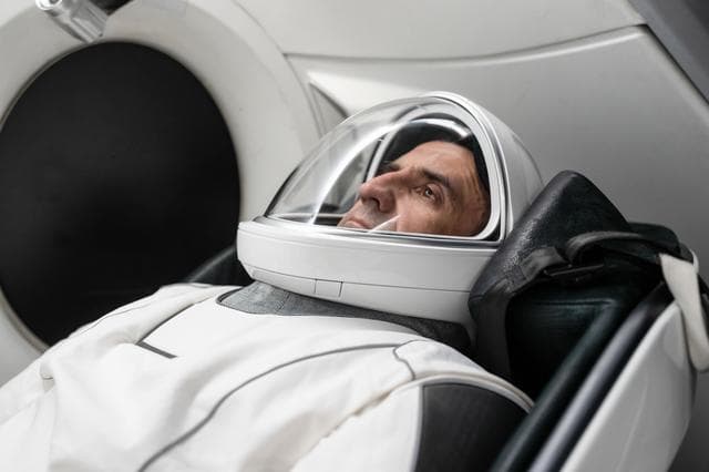 NASA image: Roscosmos cosmonaut Sergey Teteryatnikov is seated inside a mockup Dragon spacecraft