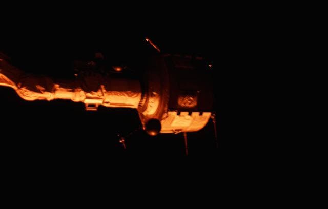 NASA image: PDP grappled by RMS is positioned above payload bay (PLB) at sunrise
