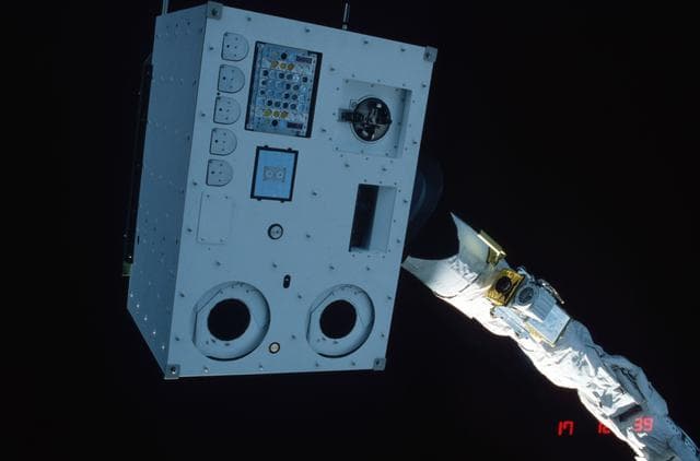NASA image: Closeups of IECM grappled by RMS and positioned above payload bay (PLB)