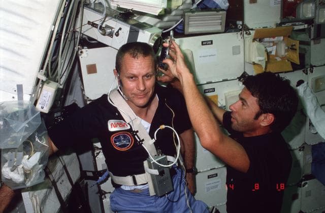 NASA image: Mission Specialist (MS) Lenoir cuts Pilot Overmyer's hair on middeck