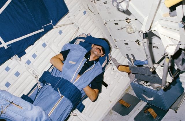 NASA image: Mission Specialist (MS) Gardner sleeps in middeck sleep restraint