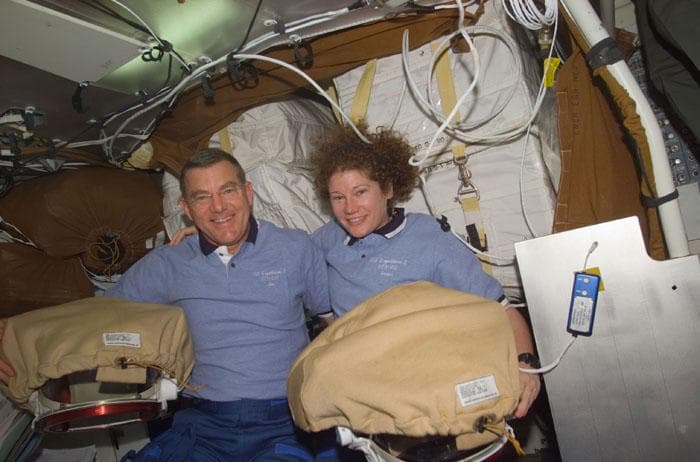 NASA image: Voss and Helms with their EMU suits in the middeck