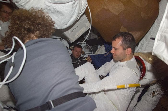 NASA image: Helms assists Richards in donning his EMU suit