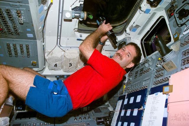 NASA image: MS Grunsfeld with binoculars on the aft flight deck