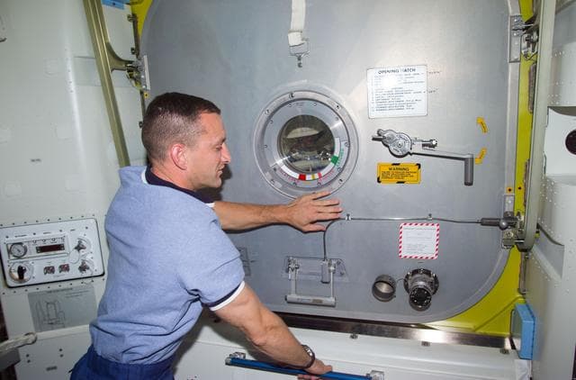 NASA image: PLT Horbaugh at Crew Lock hatch in the Airlock Quest