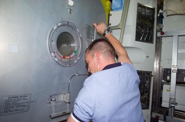 NASA image: PLT Horbaugh at Crew Lock hatch in the Airlock Quest