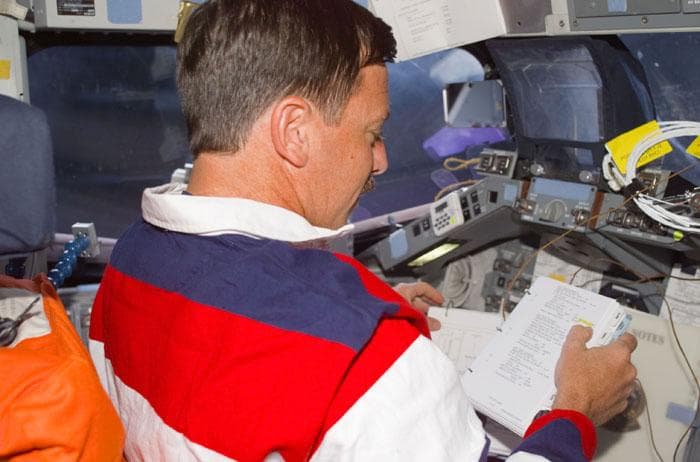 NASA image: Horowitz checks flight notes at the commander's station