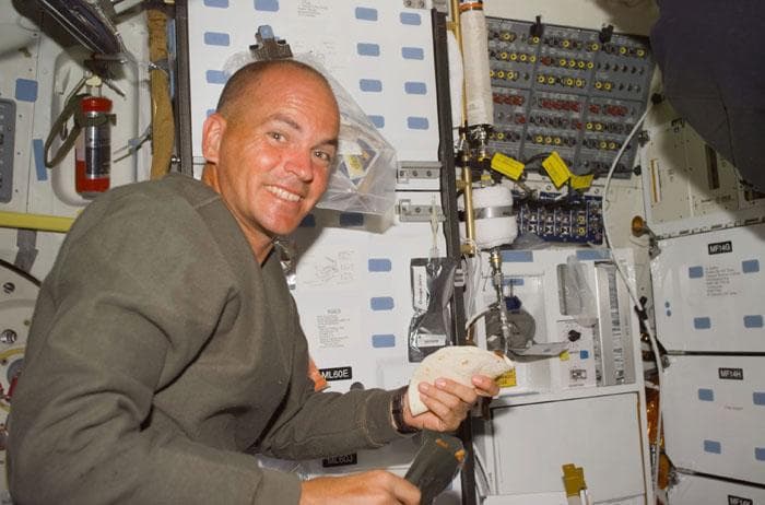 NASA image: Sturckow fixes a meal in the orbiter middeck